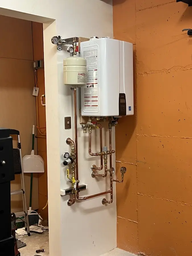 Plumbing technician inspecting water heater connections in Atmore
